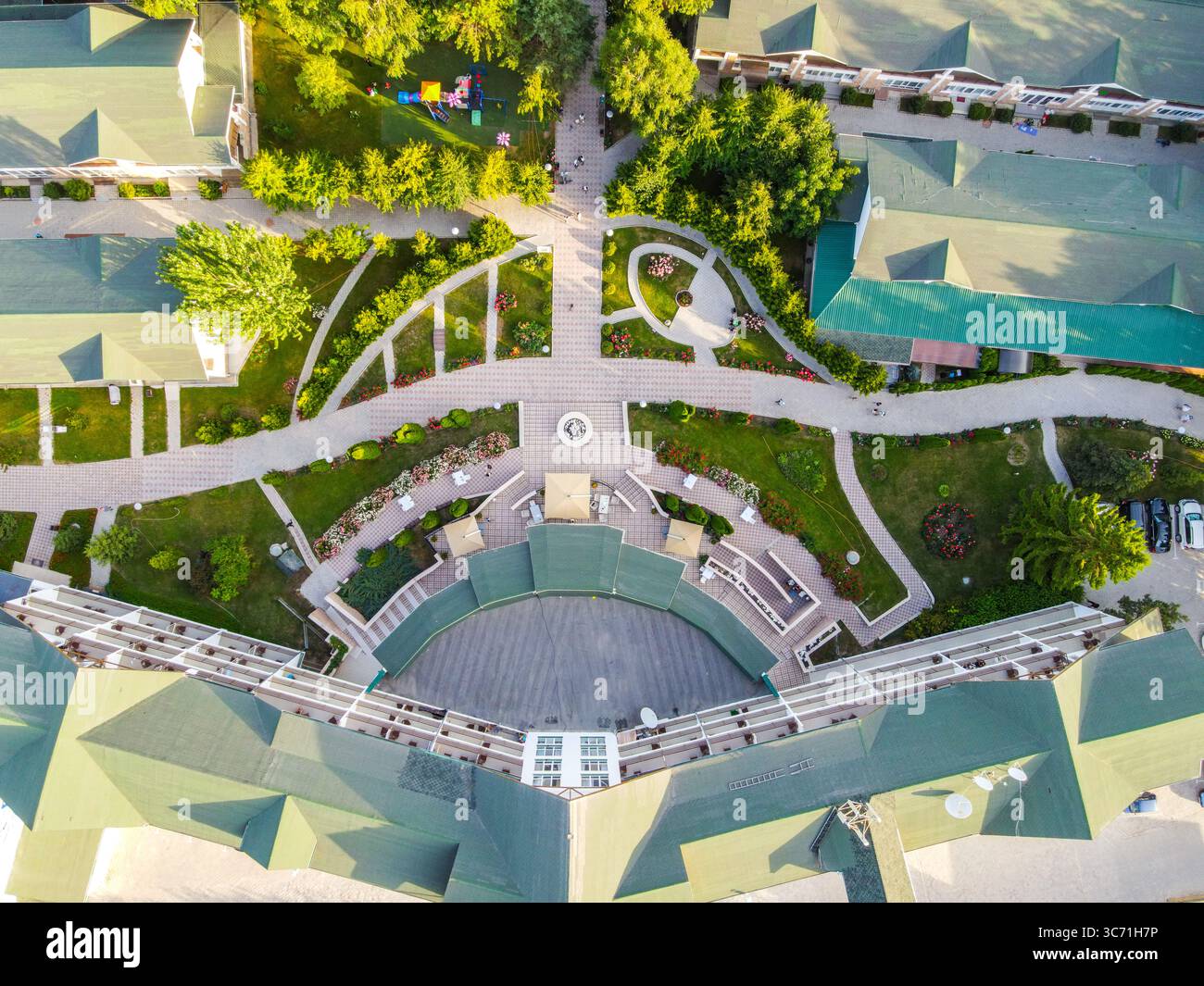 Balykchy, Kirghizistan - 12 maggio 2023: Vista aerea dall'alto verso il basso di un anfiteatro all'aperto in un resort, circondato da un giardino ben curato con passerelle e Foto Stock
