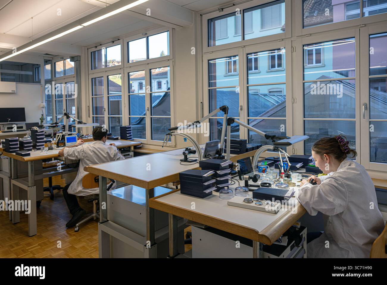 Orologiai al lavoro nel laboratorio di orologeria Oris presso la sede centrale dell’impresa a Hölstein, in Svizzera, Foto Stock
