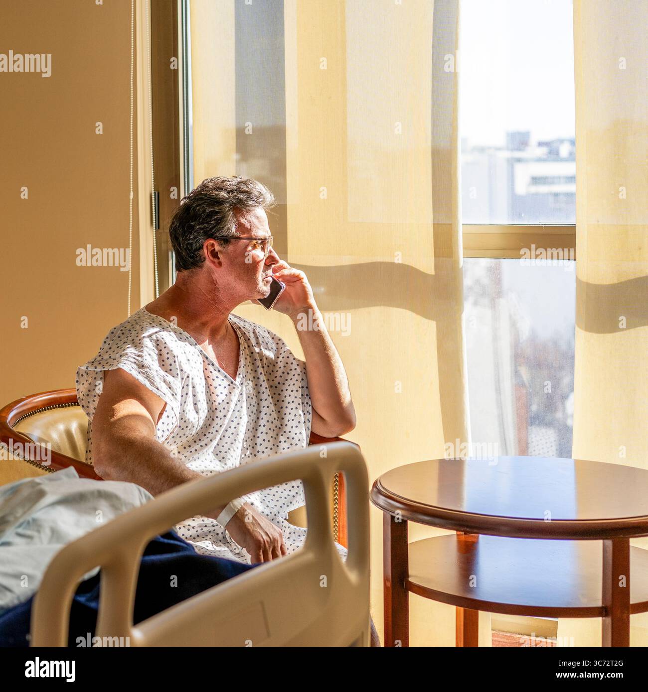 Uomo ricoverato che parla al telefono cellulare. Foto Stock