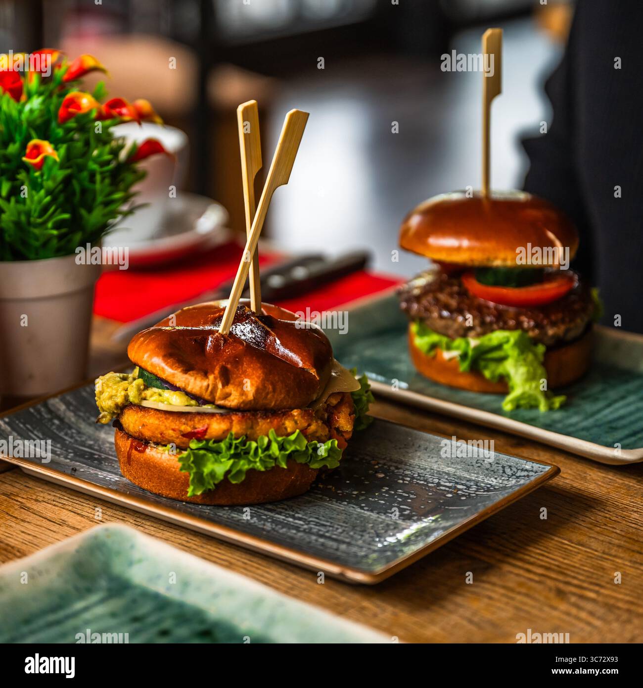 Burger vegetariano su un tavolo di legno in un ristorante, hamburger di carne sullo sfondo Foto Stock