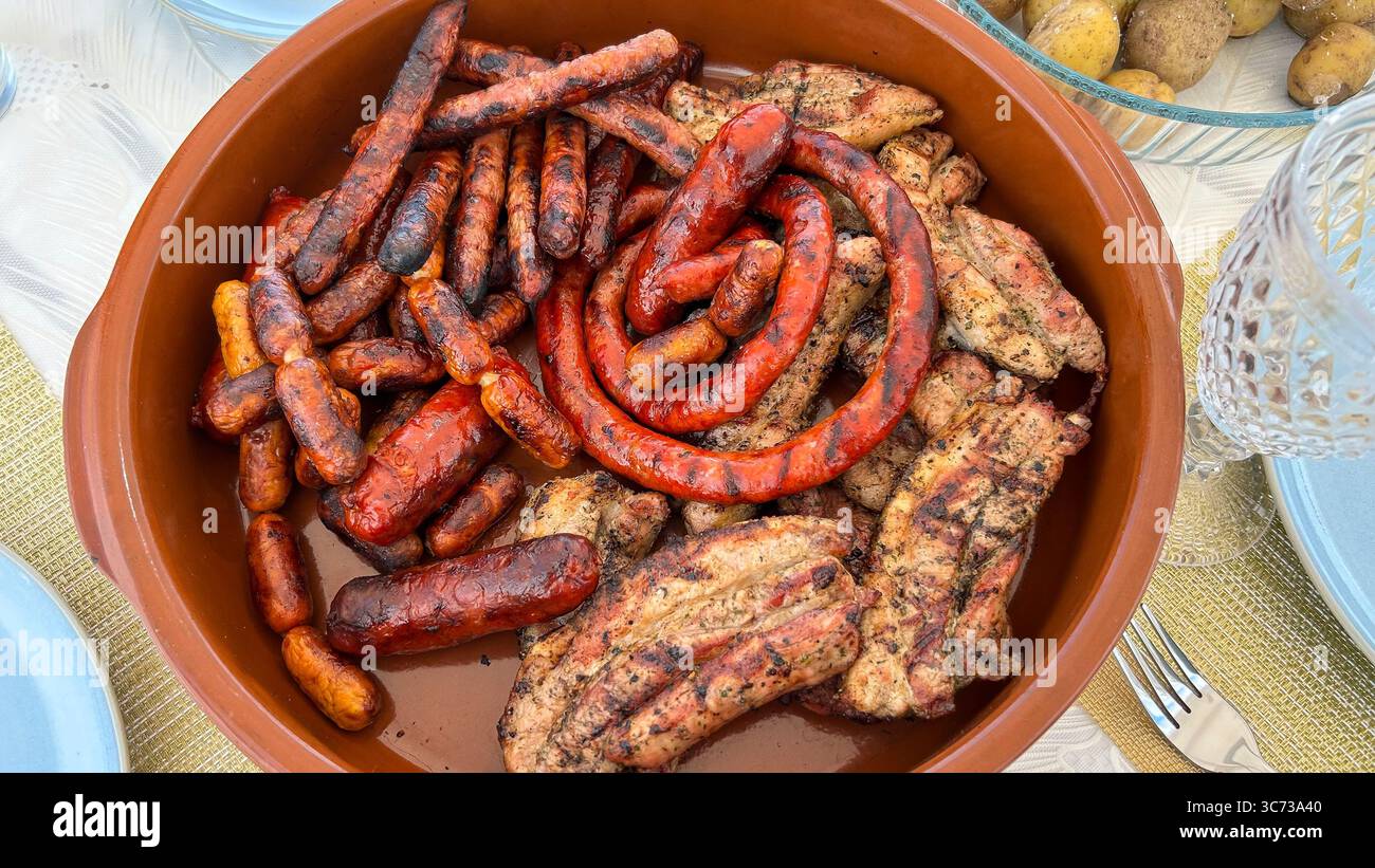 Contenitore con salsicce e carne al barbecue Foto Stock