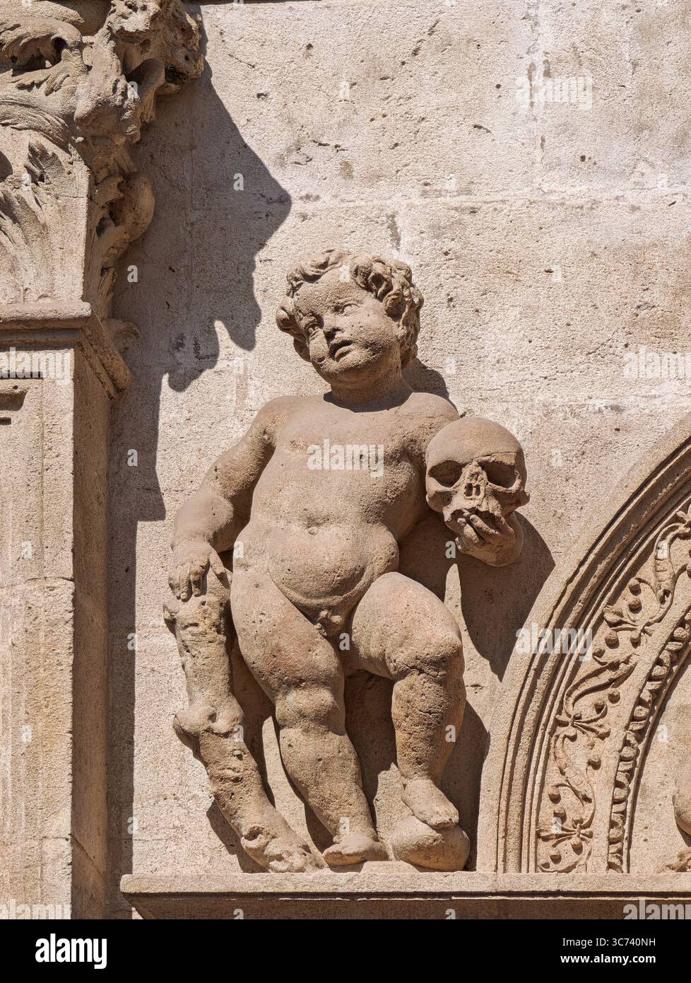 Altorilievo sulla facciata plateresca del Municipio di Siviglia presenta un cherubino che regge un teschio, che trasmette temi di mortalità. Foto Stock