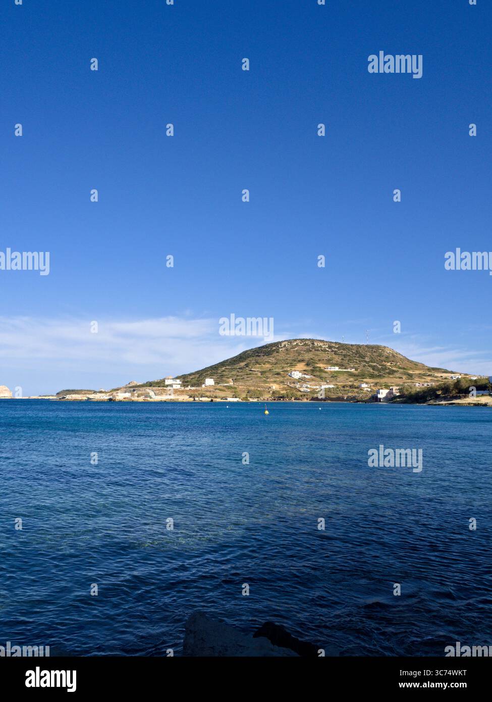 Tradizionale villaggio collinare vicino ad Apollonia, Milos, con case bianche sopra il mare in una limpida giornata estiva nelle Cicladi. Foto Stock