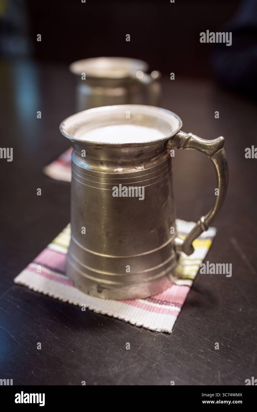 Tazze da birra giapponesi vintage piene di birra, fotografate su un tavolo di legno scuro con illuminazione soffusa e stile retrò Foto Stock