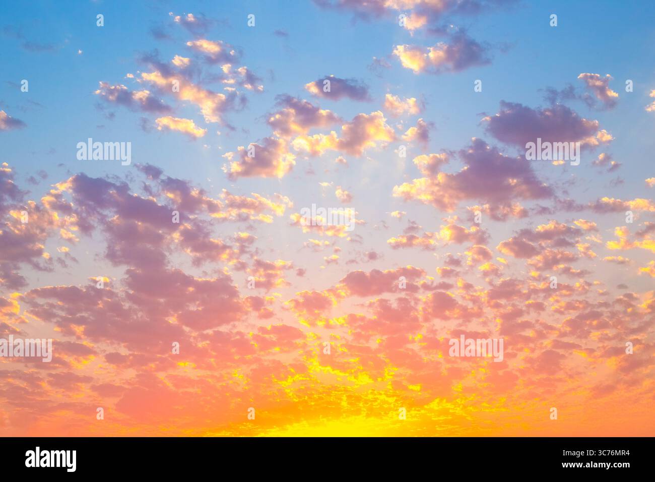 Durante il tramonto, il cielo diventa di colori brillanti e le nuvole riflettono sfumature di giallo, arancione e rosa. Foto Stock