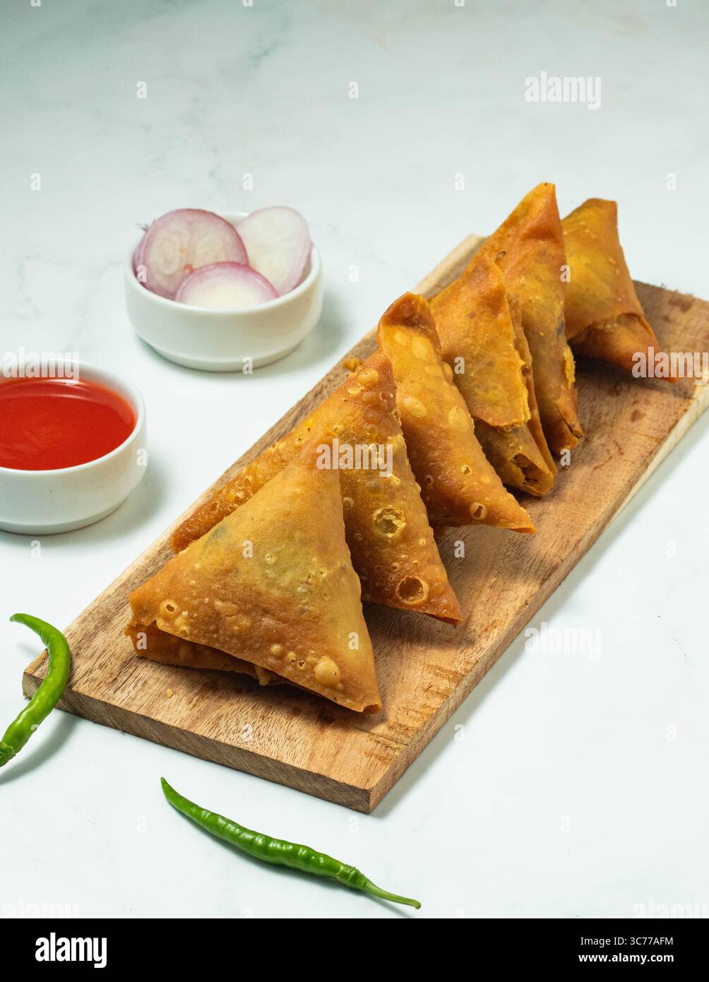 Primo piano samosa con tavola bianca e di legno sul banco. Foto Stock