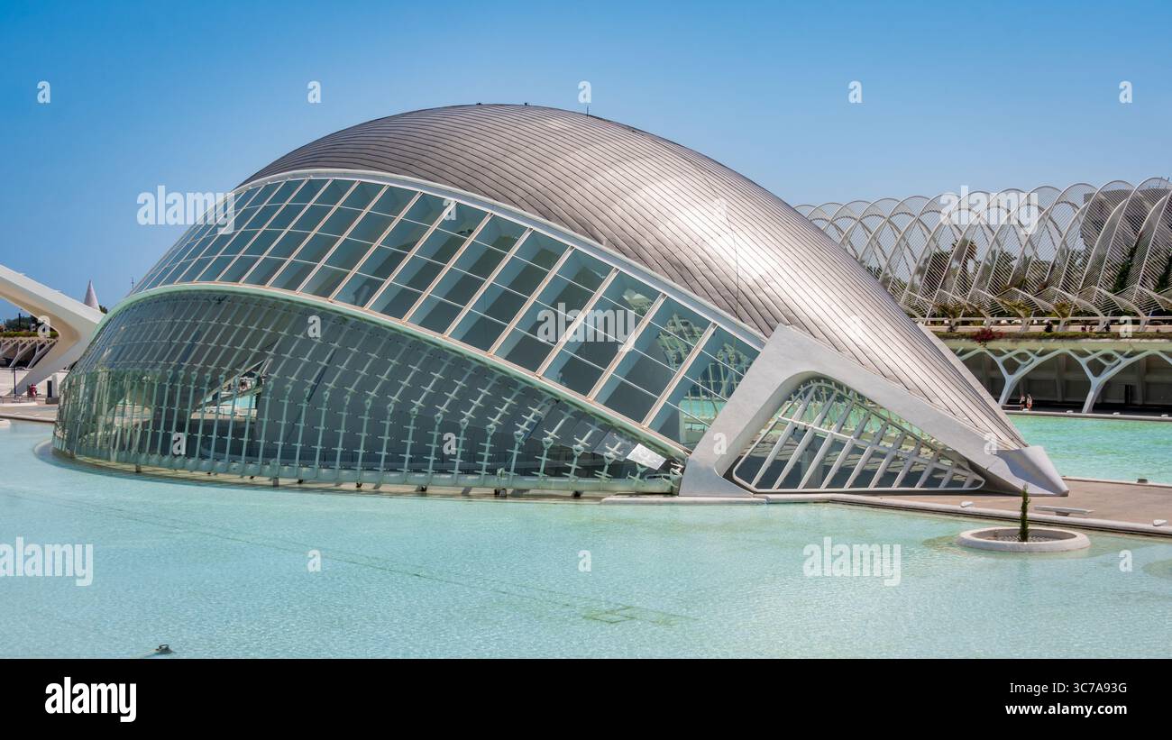 L'Hemisfèric di Valencia, Spagna, un futuristico edificio a forma di occhio di Santiago Calatrava, si riflette splendidamente nelle acque turchesi sottostanti. Foto Stock