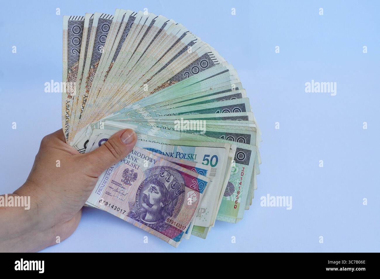 Mano che tiene il denaro isolato su sfondo bianco, valuta Baht tailandese. Foto Stock