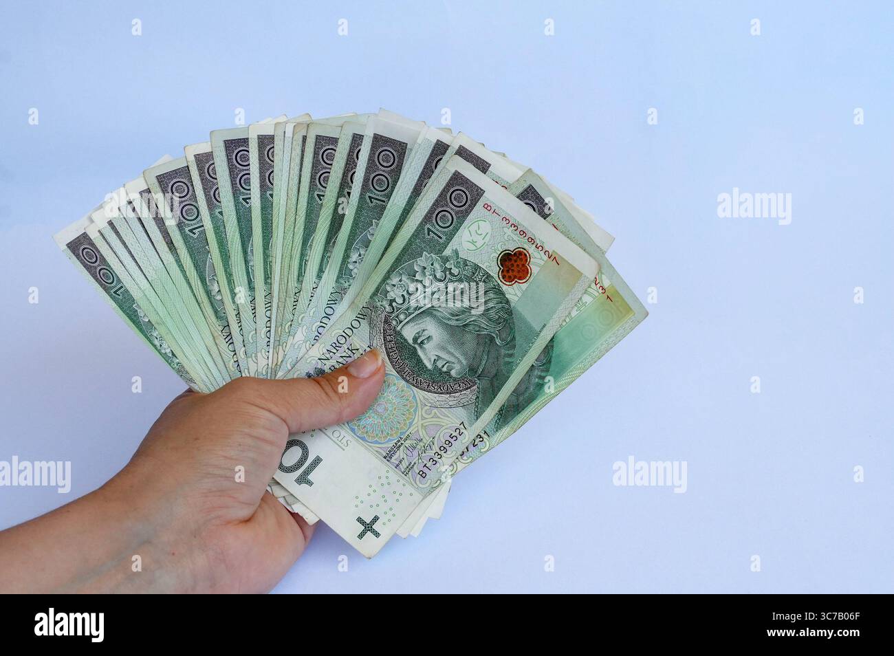Mano che tiene il denaro isolato su sfondo bianco, valuta Baht tailandese. Foto Stock