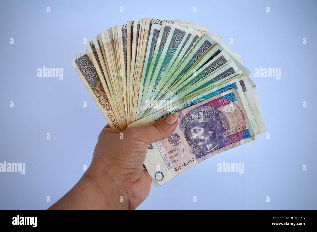 Mano che tiene il denaro isolato su sfondo bianco, valuta Baht tailandese. Foto Stock