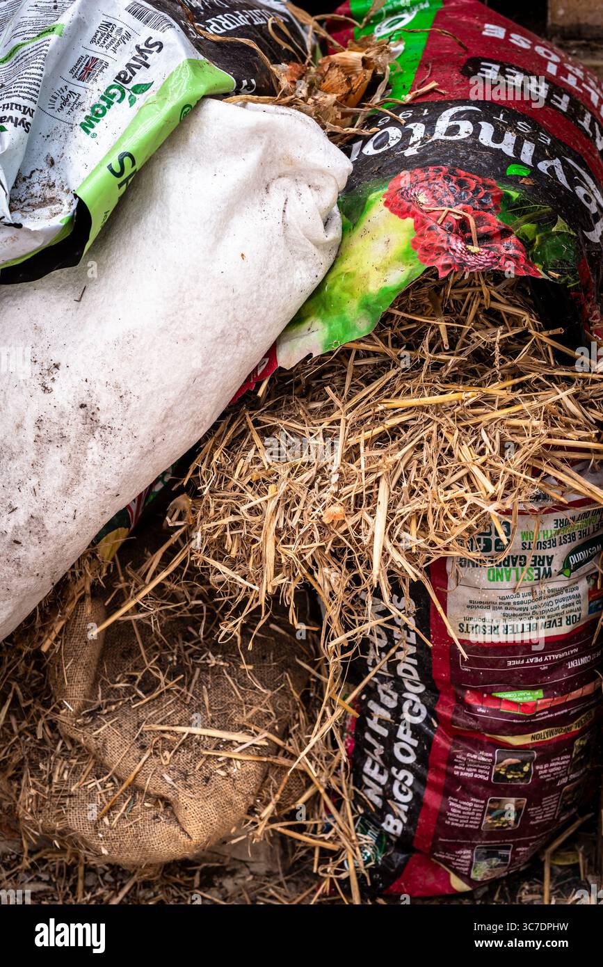 Primo piano di materiali da giardinaggio, tra cui sacchi di contenimento, sacchi di paglia e sacchi di Hessian Foto Stock
