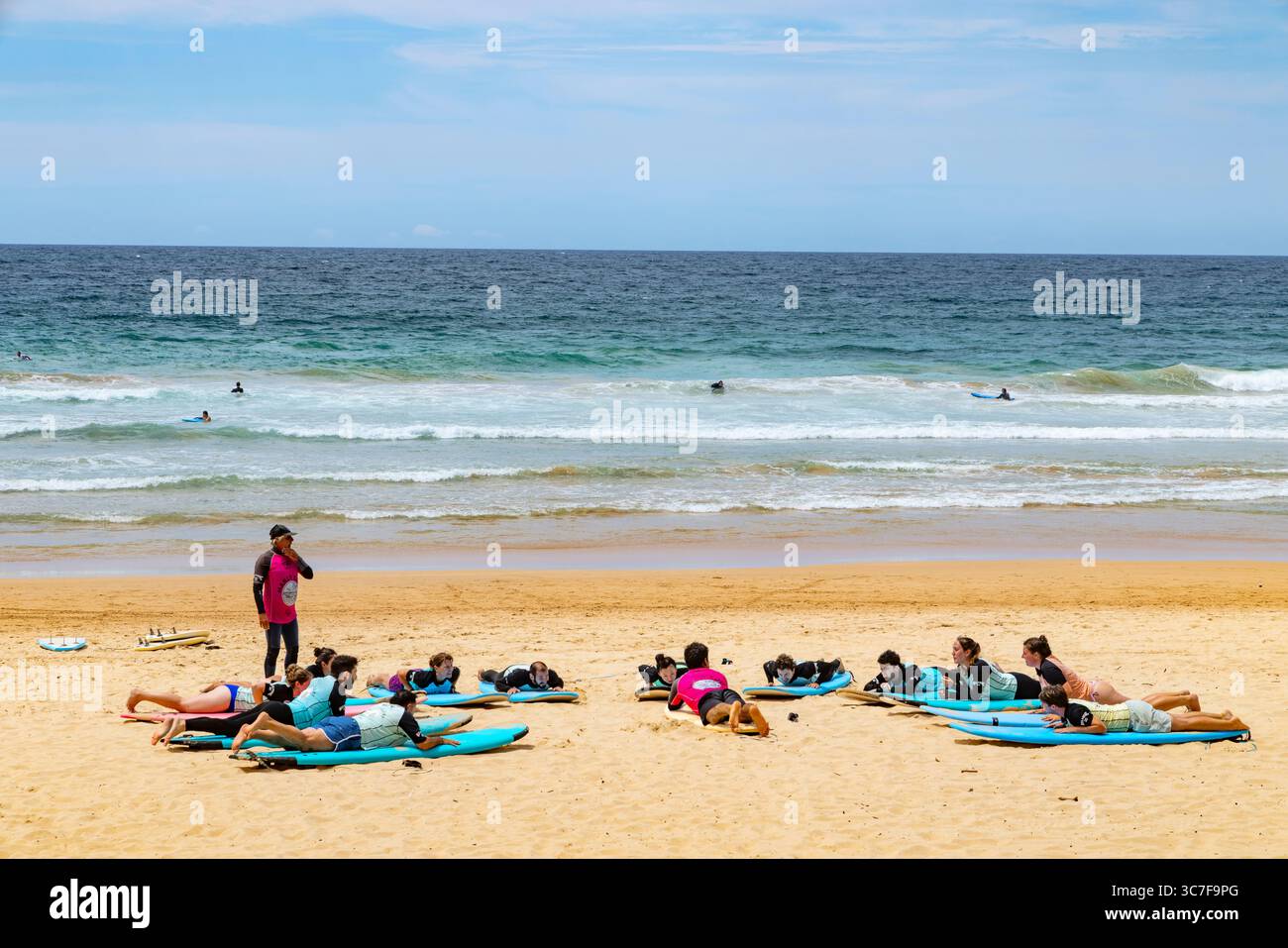 Manly Beach, Sydney, Australia, le persone che si appoggiano sulle tavole da surf ricevono istruzioni durante questa lezione di surf Foto Stock