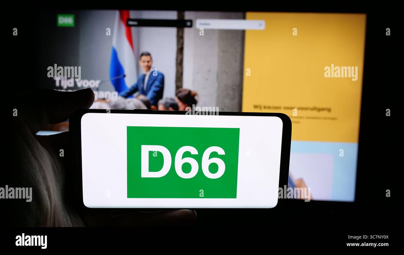 Stoccarda, Germania - 07-09-2025: Persona che tiene il cellulare con il logo del partito politico olandese Democraten 66 (D66) sullo schermo davanti alla pagina web. Foto Stock