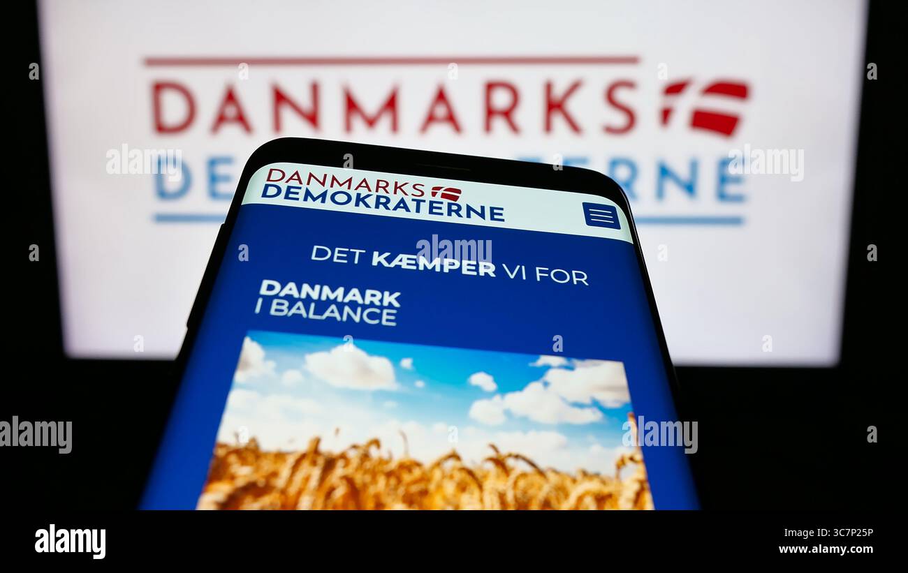 Stoccarda, Germania - 07-11-2025: Telefono cellulare con sito web del partito politico danese Danmarksdemokraterne sullo schermo davanti al logo. Foto Stock