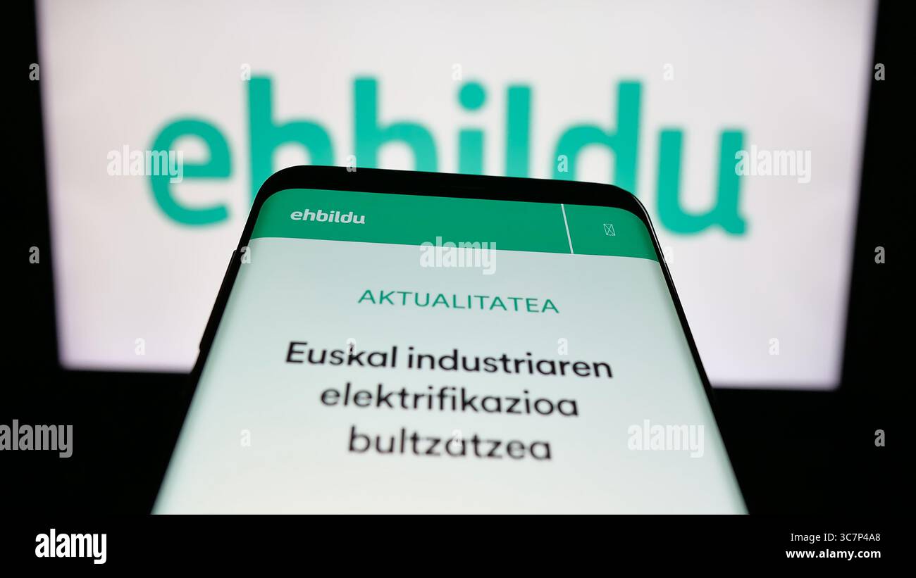 Stoccarda, Germania - 07-18-2025: Telefono cellulare con sito web della festa spagnola Euskal Herria Bildu (EHBildu) sullo schermo davanti al logo. Foto Stock