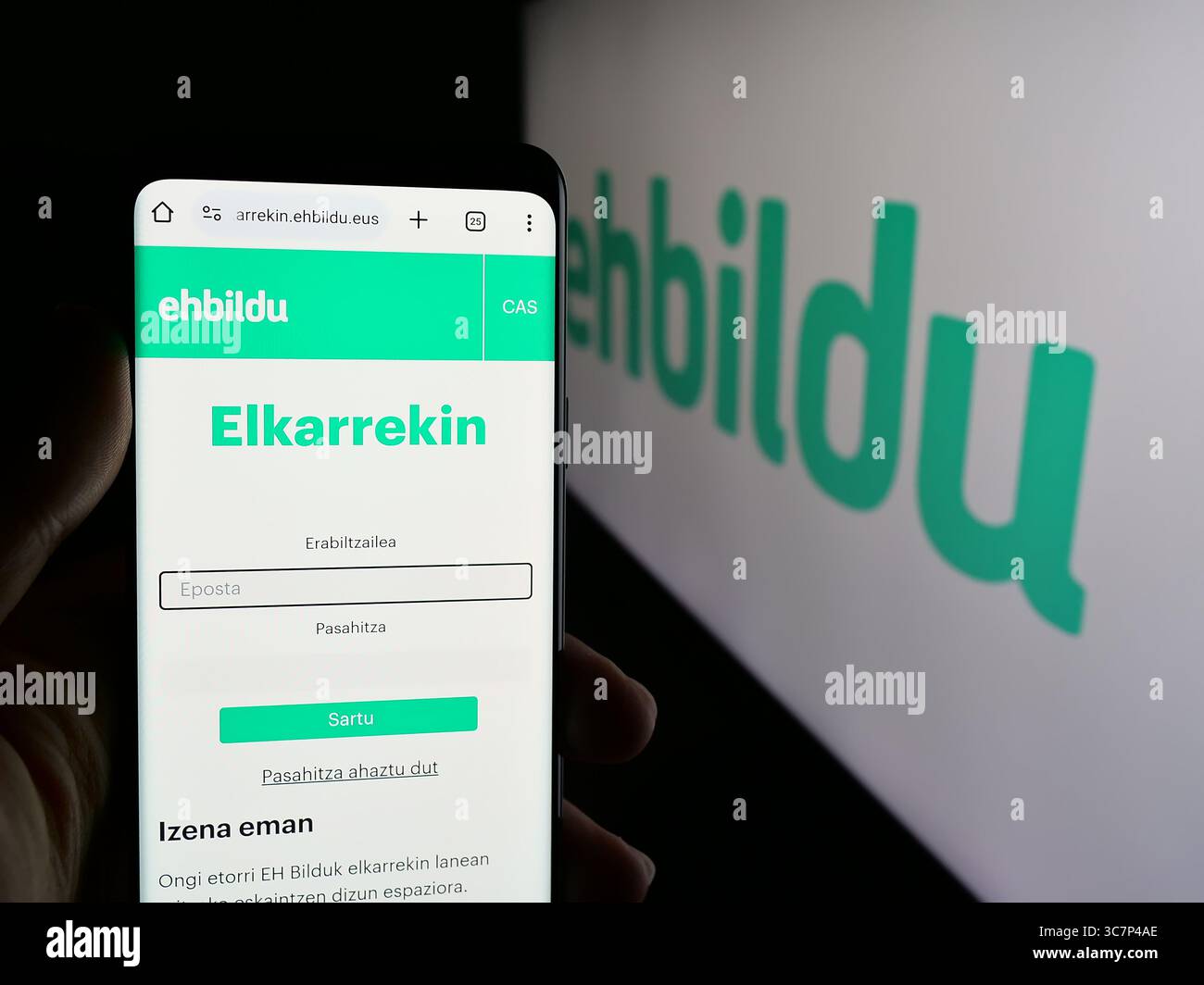Stoccarda, Germania - 07-18-2025: Persona che tiene il cellulare con pagina web della festa spagnola Euskal Herria Bildu (EHBildu) sullo schermo davanti al logo. Foto Stock