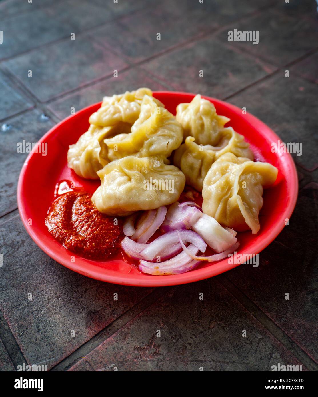 Hot Momos servito con Spicy Red Chutney in un Roadside Stall a Dehradun, India Foto Stock
