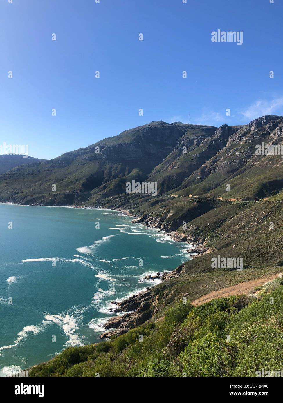 Vista pittoresca della baia di Hout a città del Capo, con acque turchesi e montagne circostanti sotto un cielo limpido. Foto Stock