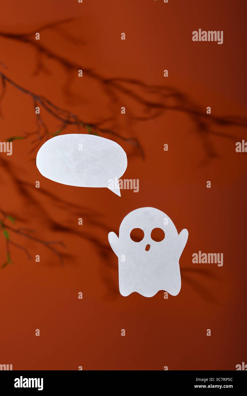 Carta bianca fantasma con una bolla per il testo su sfondo arancione con ombre dei rami degli alberi Foto Stock