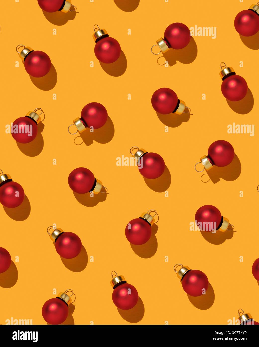 Motivo con palline di Natale rosse su sfondo giallo. Sfondo con baule in vetro. Foto Stock