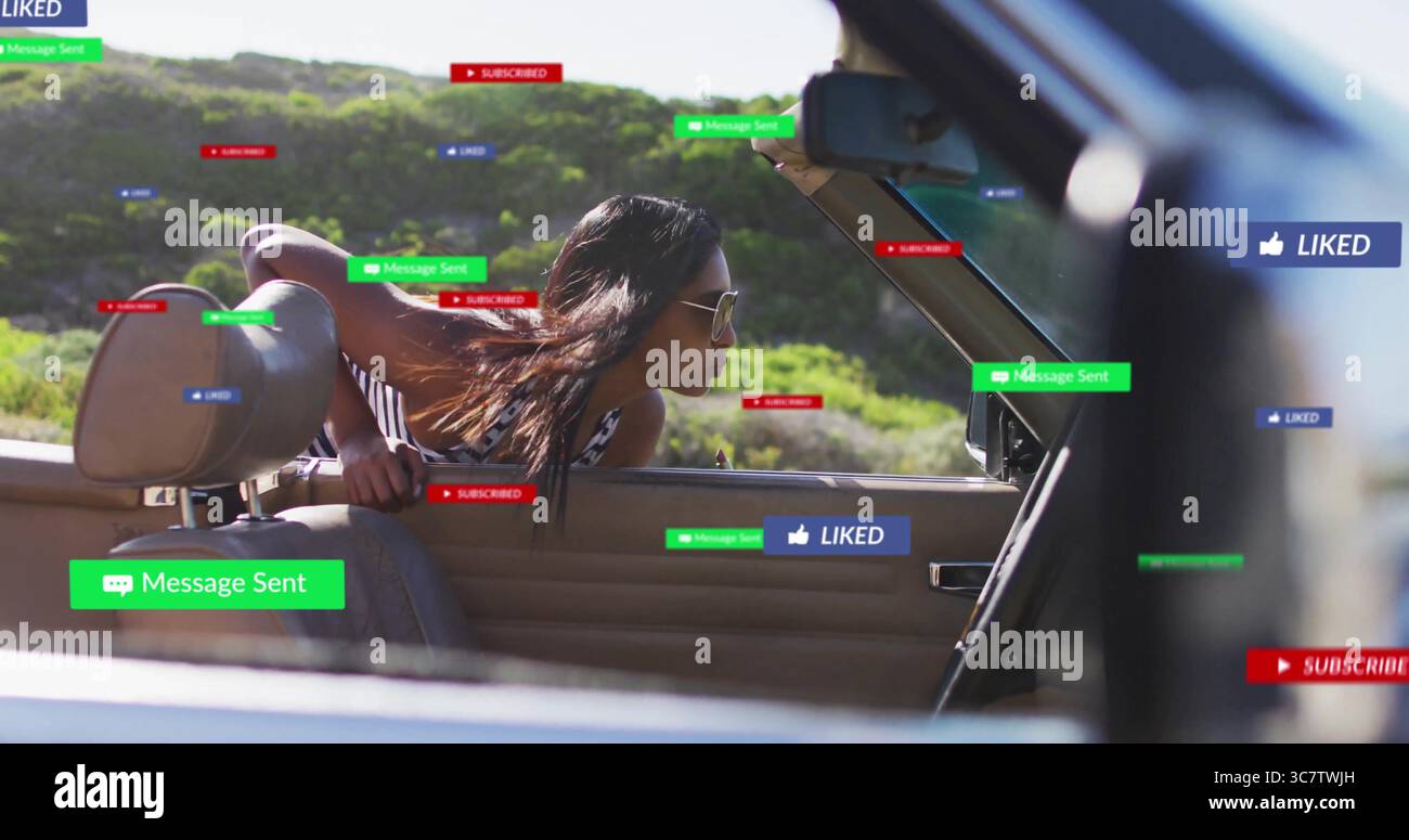 Sporgente dalla portiera lato passeggero convertibile, donna indiana che indossa la capote e occhiali da sole su strada, con icone Foto Stock