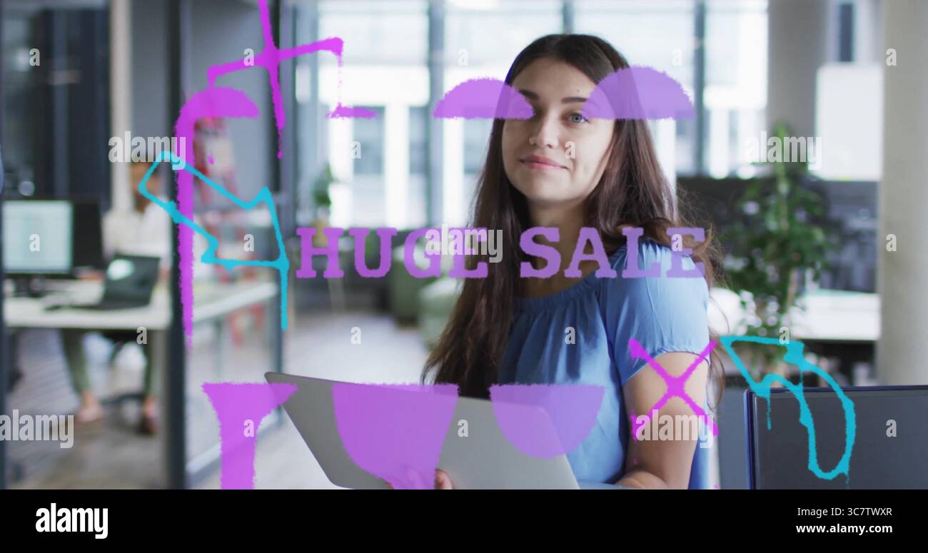 Con una camicetta blu in piedi all'interno di un ufficio open space, con pareti divisorie in vetro Foto Stock