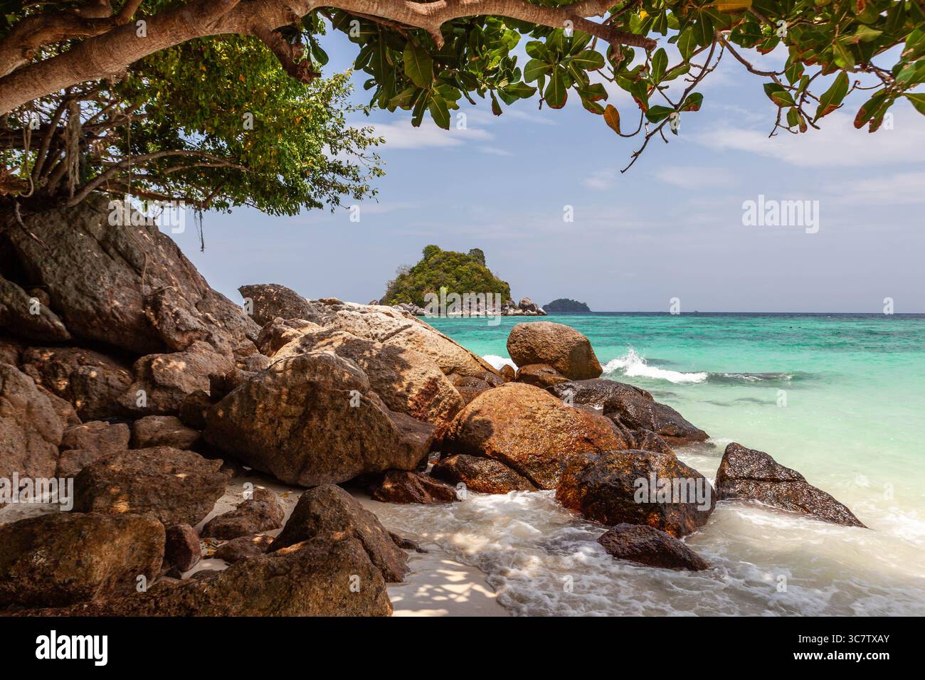 Koh Lipe, Thailandia. Un'isola tropicale nel Mare delle Andamane. Acqua di smeraldo, spiaggia di sabbia bianca, rocce, cielo blu. Foto Stock