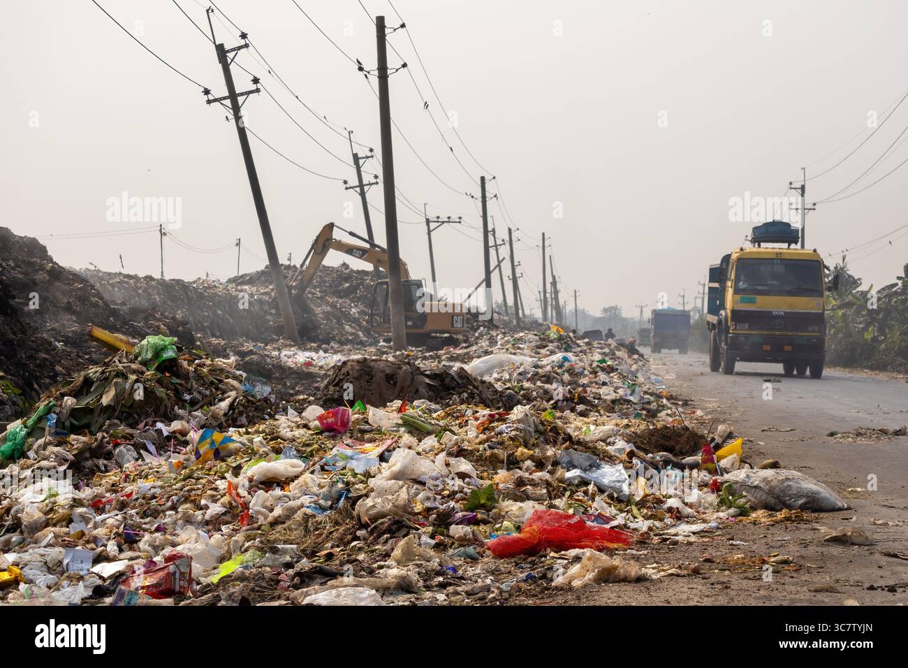 Kishoreganj, Bangladesh - 14 febbraio 2024 - pile di rifiuti domestici, industriali e medici sono lasciati sul lato della strada principale. Scarico dei rifiuti Foto Stock