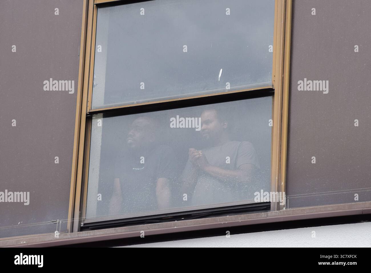 Londra, Regno Unito. 2 agosto 2025. I migranti guardano i manifestanti dalle loro camere al Thistle Hotel vicino a Barbican. Sia i manifestanti pro- che anti-migranti hanno organizzato dimostrazioni fuori dall'hotel dove sono ospitati i migranti, mentre le proteste migranti continuano. Crediti: Vuk Valcic/Alamy Live News Foto Stock