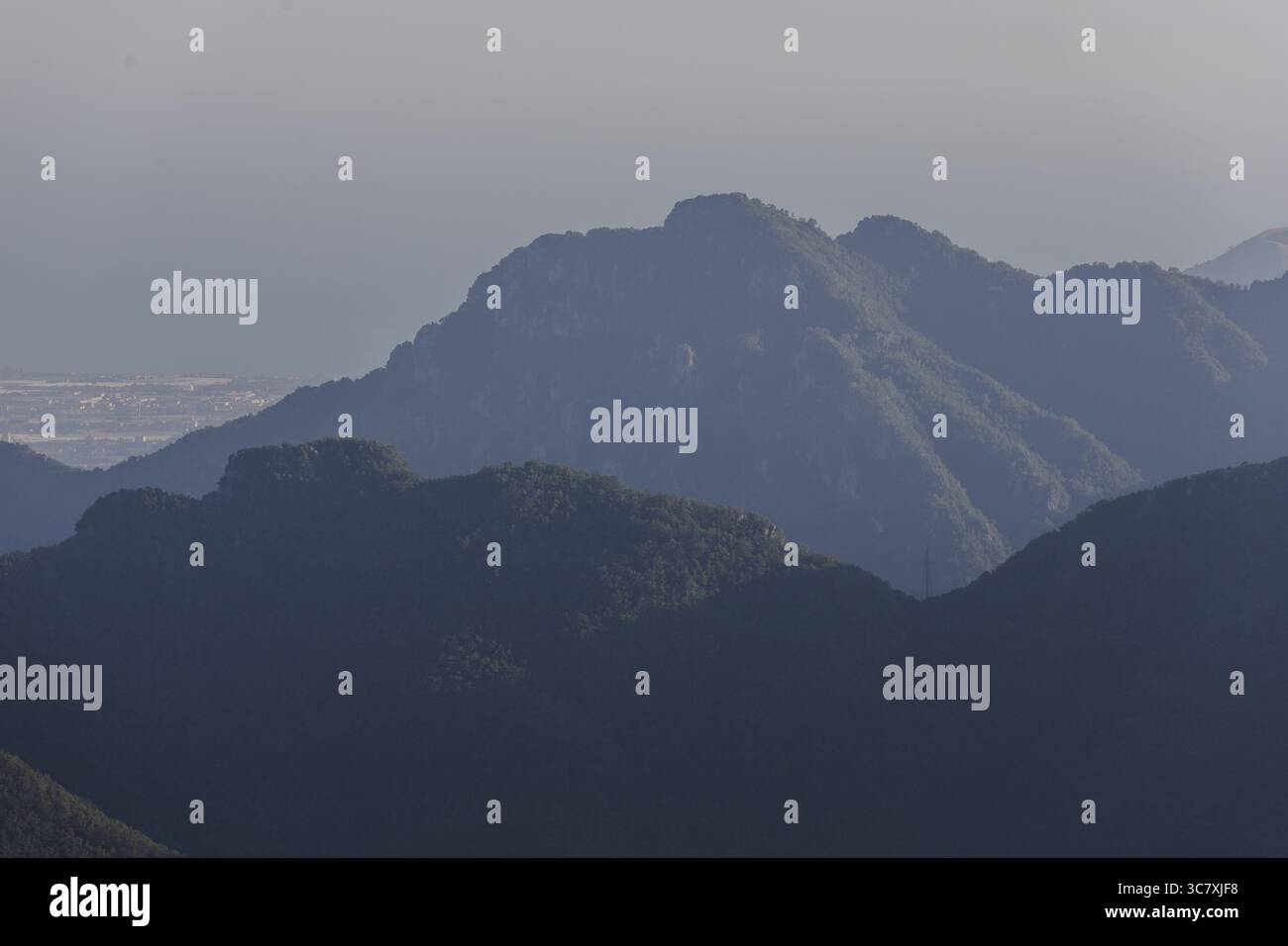 Vista delle montagne e delle loro sagome ondulate, avvolte nel morbido abbraccio di un'atmosfera nebbiosa, dipingendo una vista serena sul paesaggio, A. Foto Stock