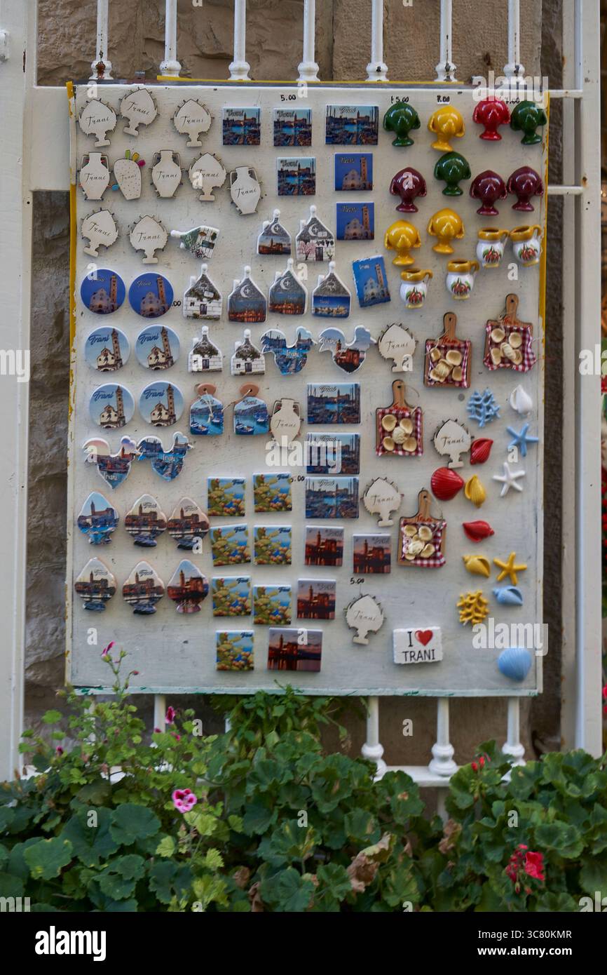 Colorata collezione di cimeli di viaggio, tra cui magneti in ceramica, cartoline e artigianato locale esposti per la vendita ai visitatori Foto Stock