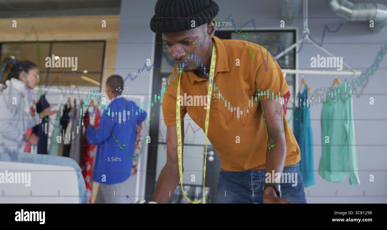 Designer pendente che indossa camicia di senape e berretto che controlla gli schizzi nello showroom con un metro a nastro Foto Stock