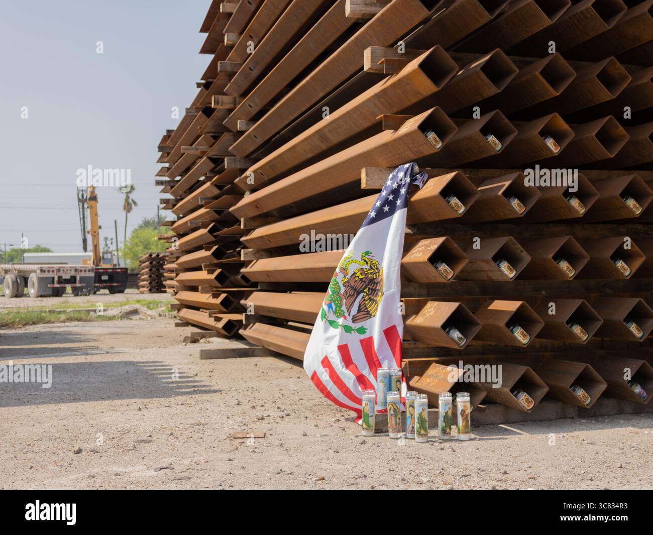 Fotografia di frammenti di muro di confine tra Stati Uniti e Messico con una bandiera messicana americana, scattata a Pharr, Texas, che illustra il complesso paesaggio culturale. Foto Stock