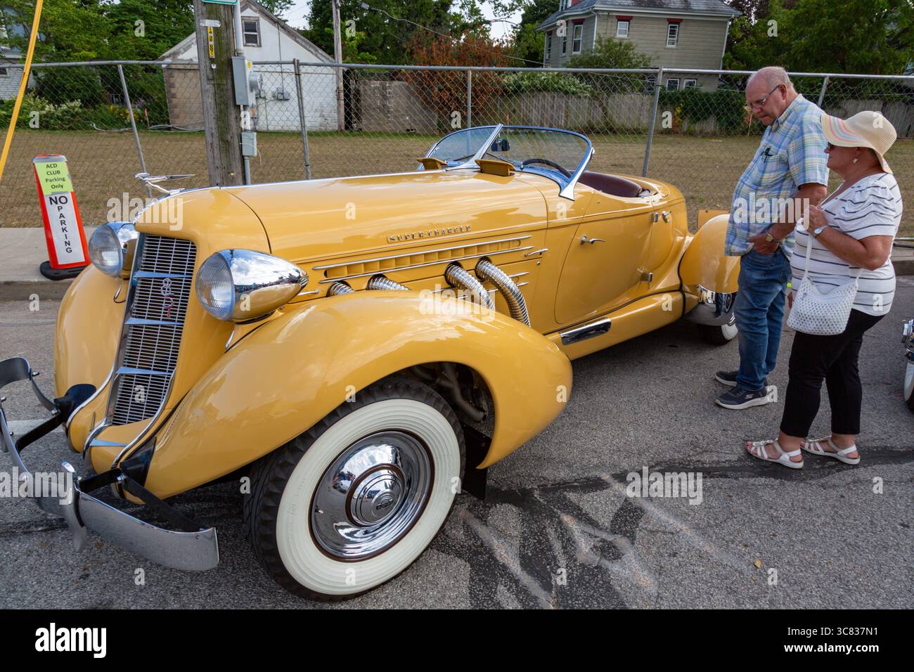 Un paio di persone ispezionano un Auburn Boattail Speedster giallo in mostra ad una mostra di auto ad Auburn, Indiana, USA. Foto Stock
