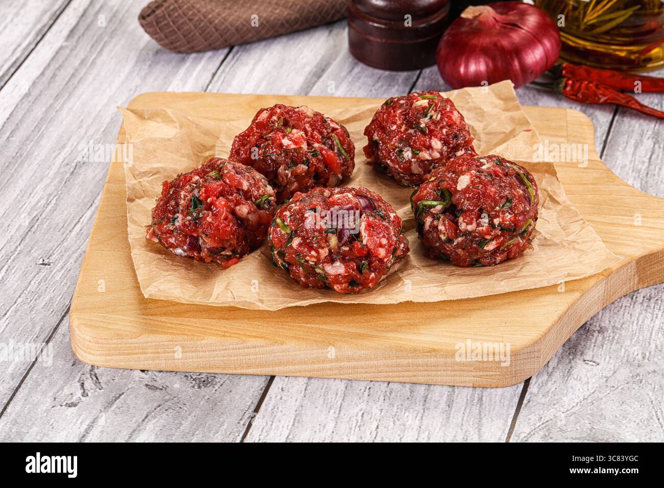 Polpette di manzo crude fatte in casa per cucinare Foto Stock