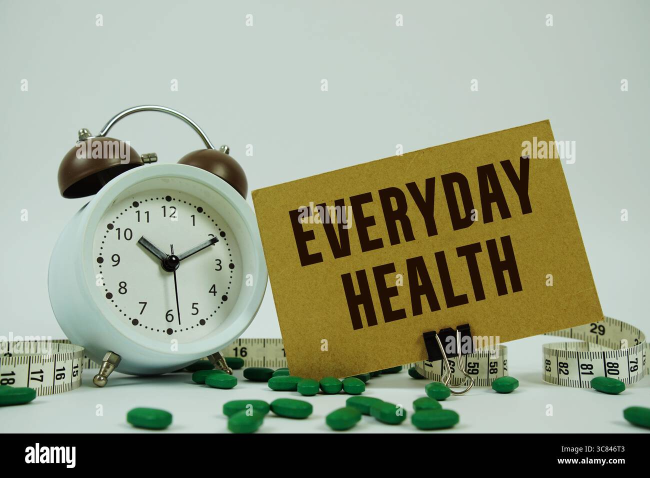 Testo Everyday Health con medicina, sveglia e metro su sfondo bianco Foto Stock