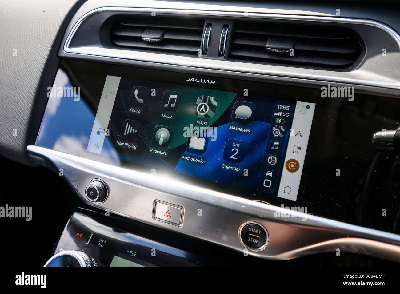 Questa immagine mette in evidenza la nuova versione iOS 26 di Apple CarPlay, che presenta elementi dell'interfaccia utente in vetro liquido traslucido, widget e uno stile di notifica compatto Foto Stock