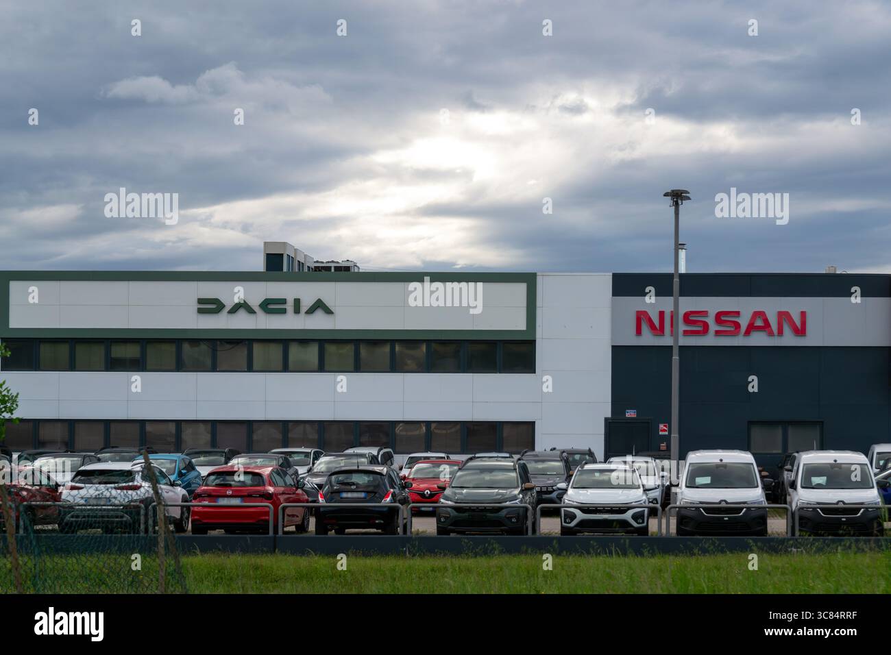 Muggia, Italia - 26 aprile 2025: Concessionaria Dacia e Nissan con veicoli parcheggiati Foto Stock