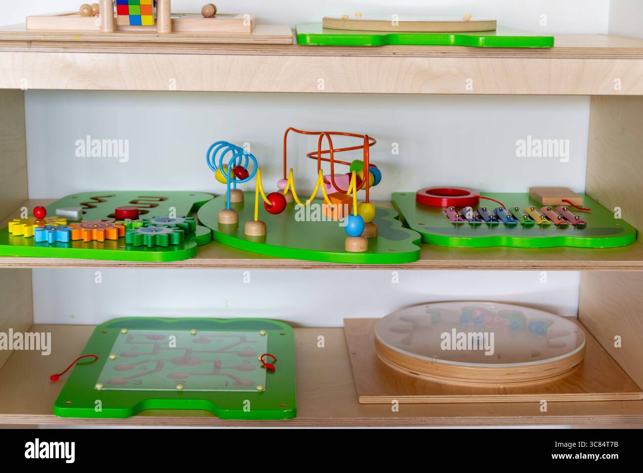 Giocattoli educativi Montessori su ripiano in legno in aula prescolare, giocattoli ecologici sostenibili Foto Stock
