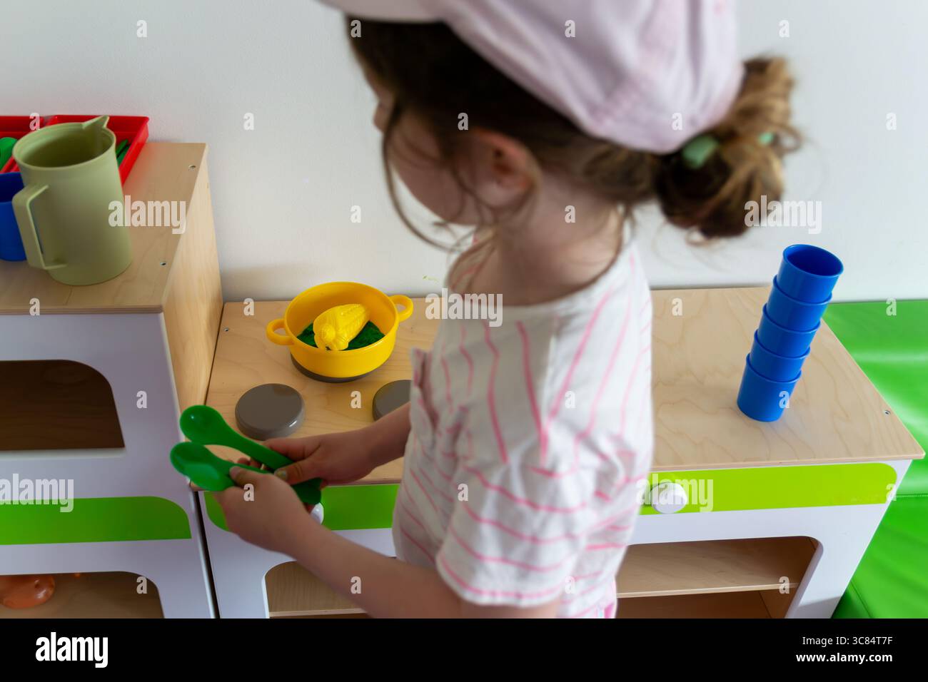 Bambini in età prescolare impegnati in un gioco fantasioso con il set da cucina giocattolo Foto Stock