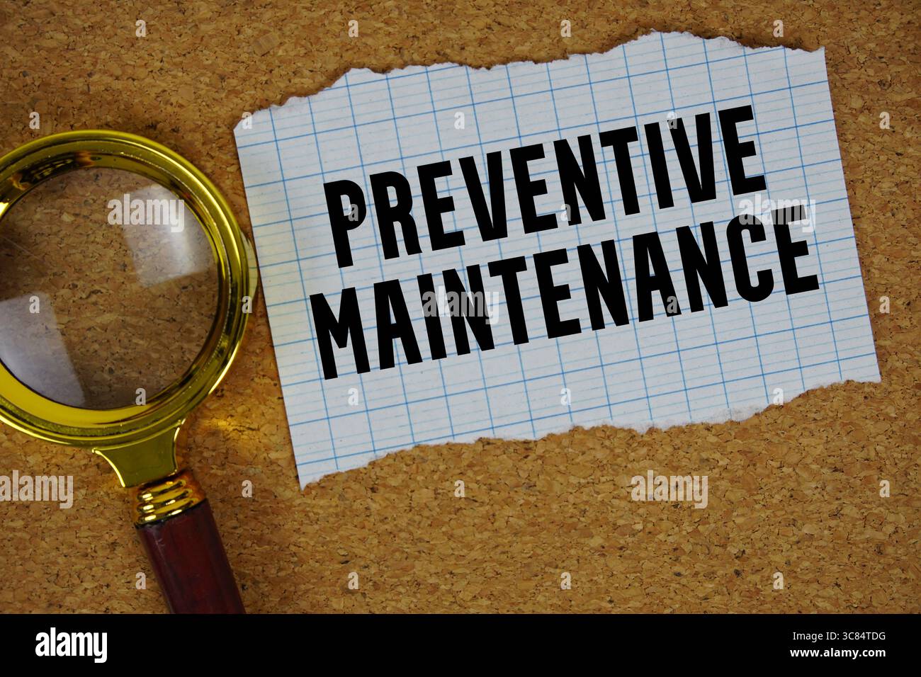 Testo sulla manutenzione preventiva scritto su carta con lente d'ingrandimento Foto Stock