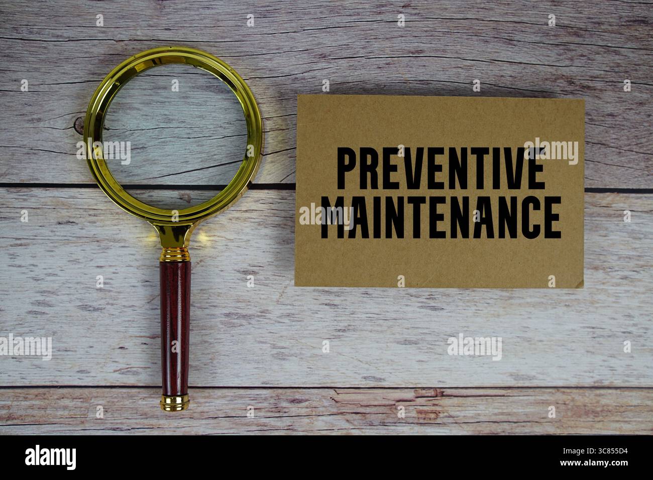 Testo sulla manutenzione preventiva scritto su carta con lente d'ingrandimento Foto Stock