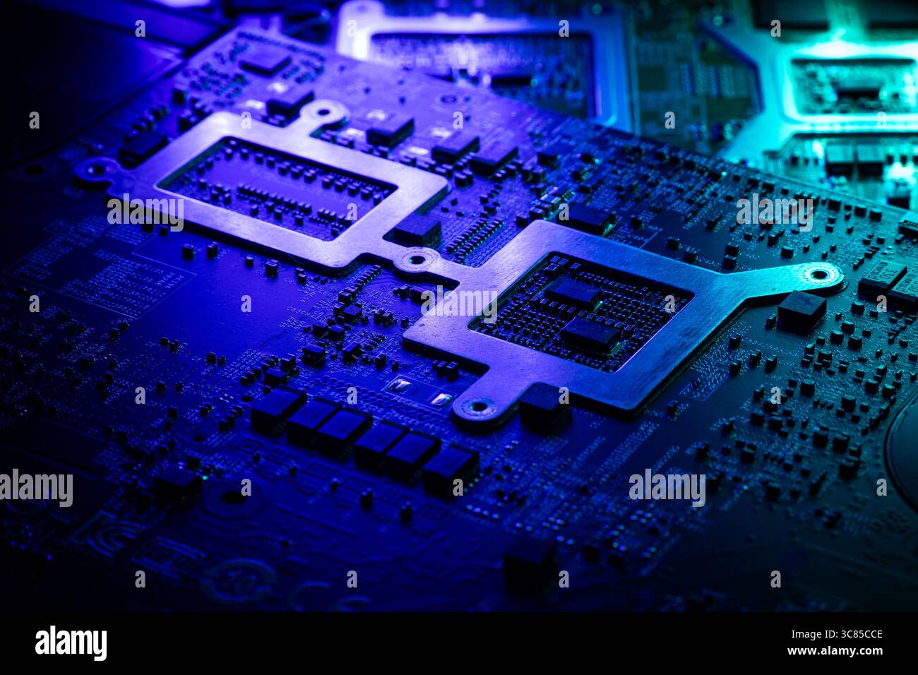 Vista macro dei componenti interni del laptop e del circuito stampato con illuminazione futuristica verde e blu Foto Stock