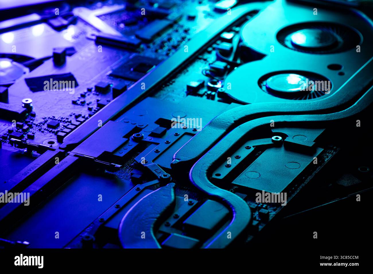 Primo piano di un sistema di raffreddamento GPU ad alte prestazioni con due ventole sotto una spettacolare illuminazione blu e verde Foto Stock