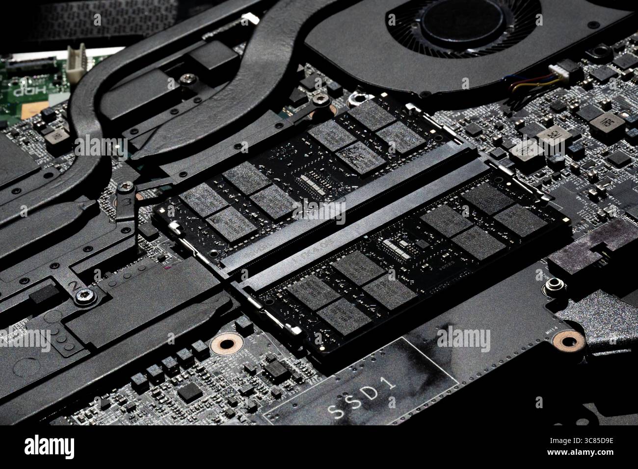 Primo piano della scheda madre per notebook con moduli RAM, sistema di raffreddamento e circuiti PCB dettagliati in primo piano Foto Stock