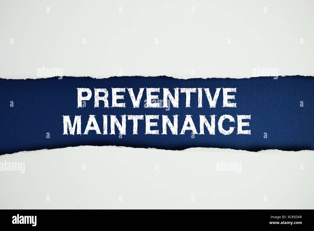 Testo manutenzione preventiva su blu scuro con carta bianca strappata in orizzontale Foto Stock