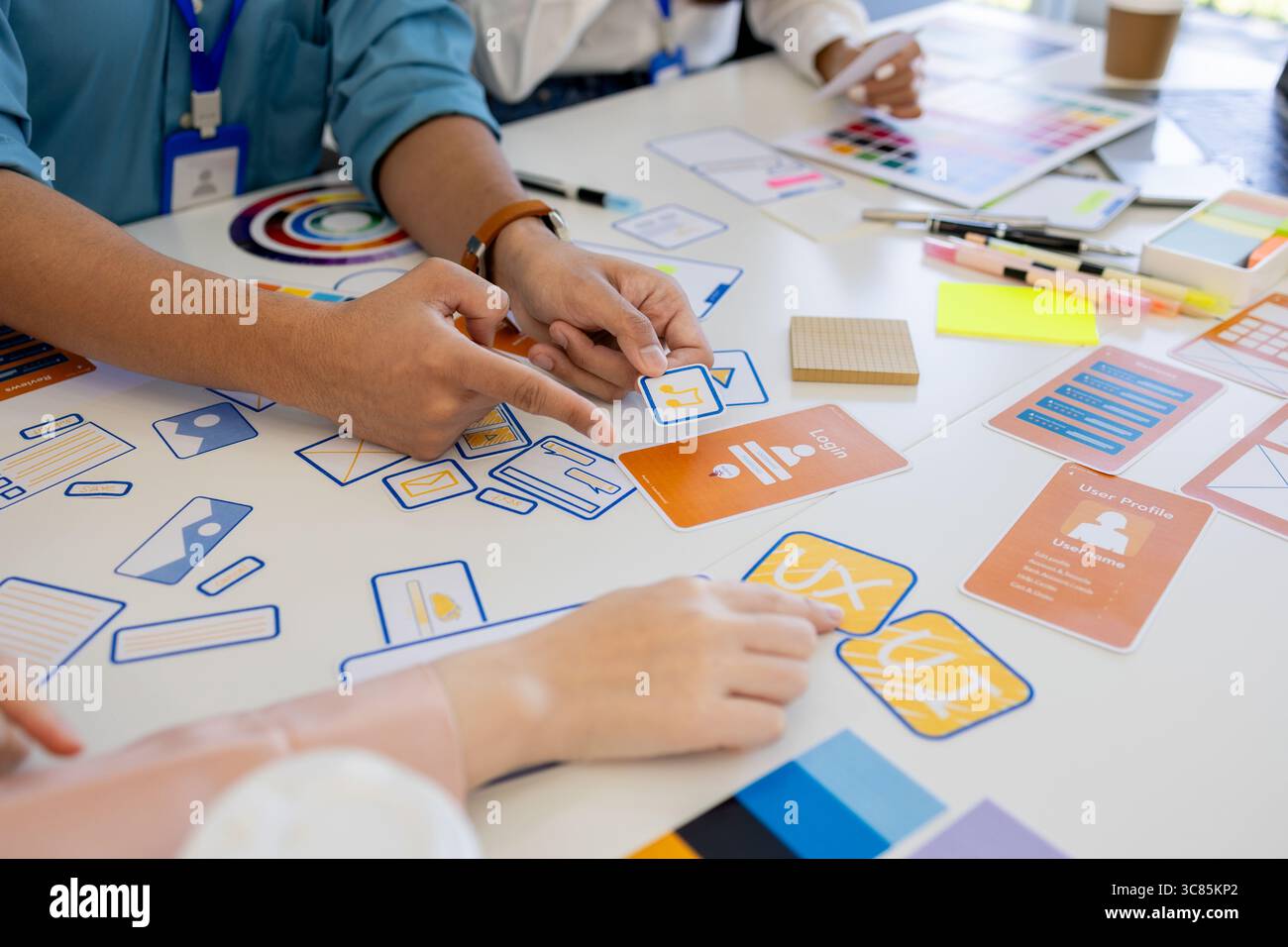 i progettisti di ux, ui, web e app mobili stanno discutendo dell'aspetto del sito web o dell'app che stanno progettando, inclusi schemi di colori e layout Foto Stock