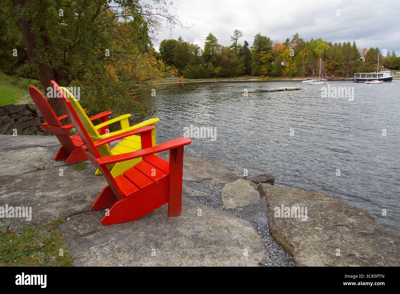 Tre sedie Adirondack colorate con vista sul lago Foto Stock