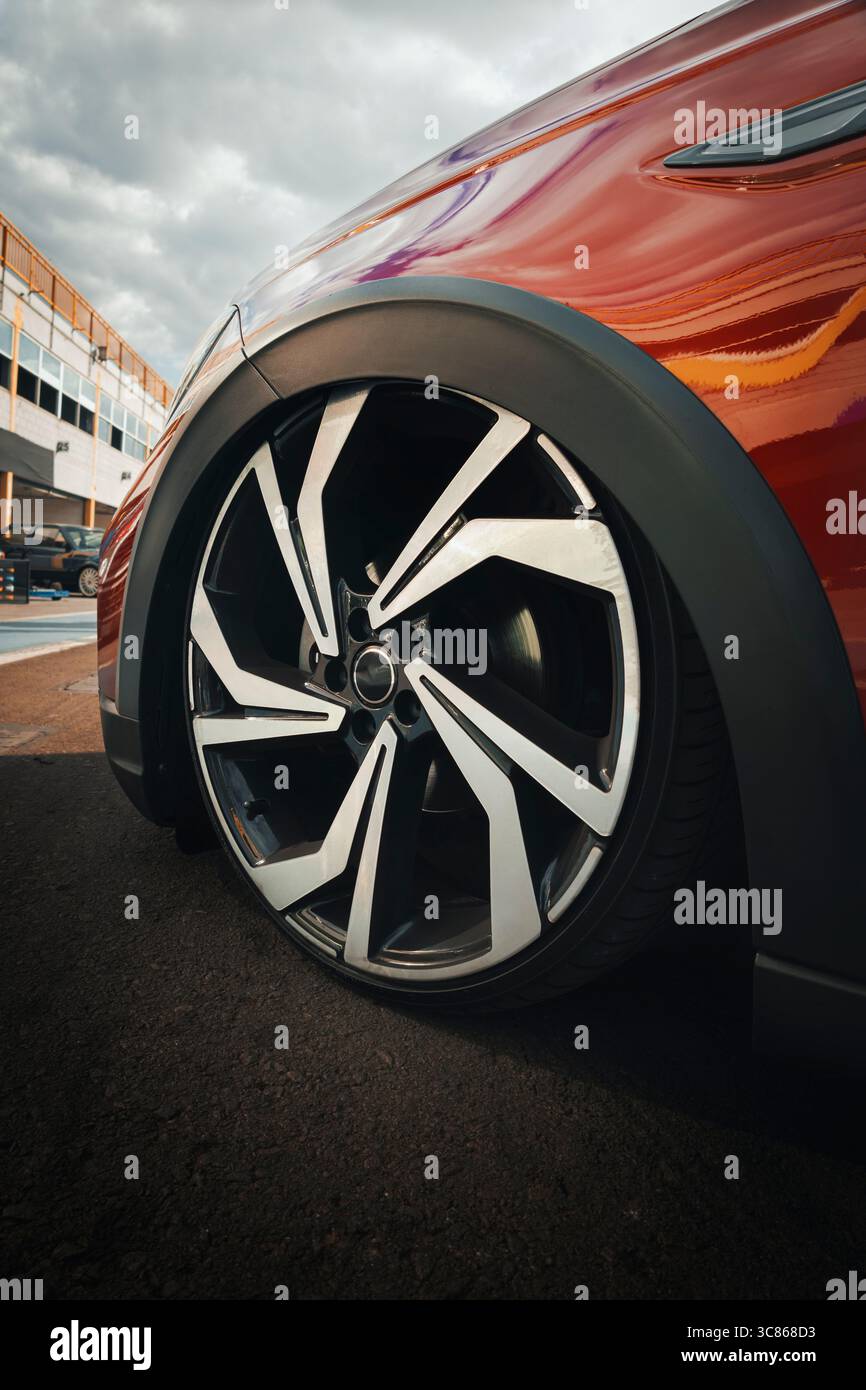 Cerchi in lega a più razze per auto con finitura diamantata, montati su uno pneumatico a profilo ribassato, evidenziando la sospensione abbassata e il montaggio a filo con Foto Stock