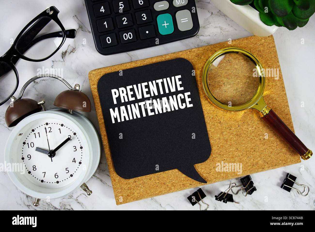 Testo manutenzione preventiva con calcolatrice, sveglia e lente di ingrandimento su sfondo in marmo Foto Stock